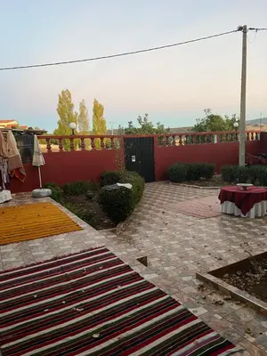 a patio with a red fence and a rug at Gite taymate in Zaouia Ben Smine