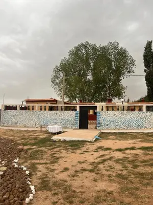 a building with a blue and white wall at Gite taymate in Zaouia Ben Smine