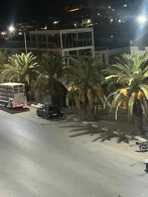 a bus driving down a street with palm trees at Bel appartement en plein Taza in Taza