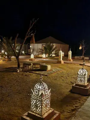 a park with a birdcageitures in a park at night at Sandside Luxury Camp in Merzouga
