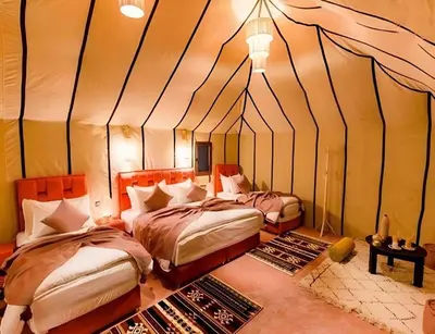 a bedroom with two beds in a tent at Sandside Luxury Camp in Merzouga