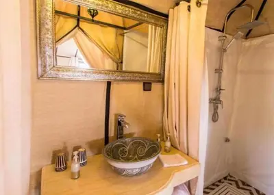 a bathroom with a sink and a mirror at Sandside Luxury Camp in Merzouga
