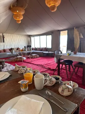 a table with plates and cups on top of it at Sandside Luxury Camp in Merzouga