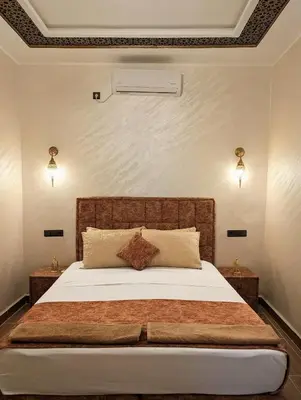 a bedroom with a large bed with white sheets at Luxury Merzouga Appartement in Merzouga