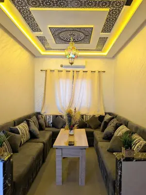 a living room with a couch and a table at Luxury Merzouga Appartement in Merzouga
