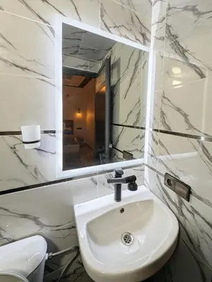 a bathroom with a white sink and a mirror at Luxury Merzouga Appartement in Merzouga