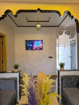 a living room with a tv on a wall at Luxury Merzouga Appartement in Merzouga