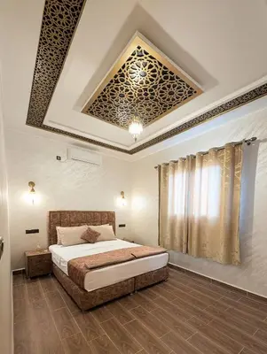a bedroom with a bed and a coffered ceiling at Luxury Merzouga Appartement in Merzouga