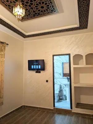 a room with a wall with a tv on it at Luxury Merzouga Appartement in Merzouga
