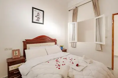 a bedroom with a bed with red rose petals on it at Maison authentique Ourika avec vue sur l'Atlas in Ourika