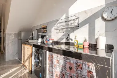 a kitchen with a washing machine and a clock on the wall at Maison authentique Ourika avec vue sur l'Atlas in Ourika
