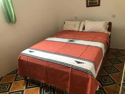 a small bed in a corner of a room at Dar Kakun in Oulad Akkou
