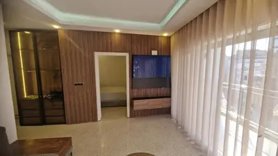 a hallway with a room with a television on a wall at Princière Downtown apartment, Fiber optic in Oulad Akkou