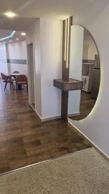 a living room with a mirror and a table at Princière Downtown apartment, Fiber optic in Oulad Akkou