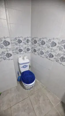 a bathroom with a toilet with a blue seat at Princière Downtown apartment, Fiber optic in Oulad Akkou