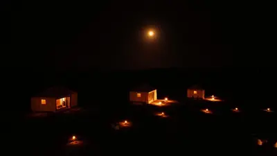 a group of houses at night with a full moon at Luxury Queen Camp in Tisserdmine
