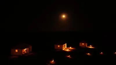 a group of cottages in the dark at night at Luxury Queen Camp in Tisserdmine