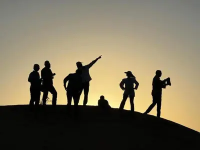 a group of people standing on top of a hill at Planet Camp Désert Tours in Mhamid