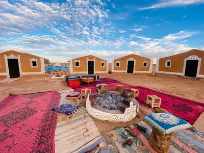 a group of camp huts in the desert at Planet Camp Désert Tours in Mhamid