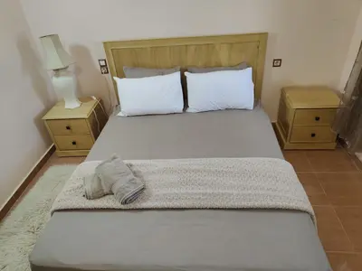 a bedroom with a large bed with two night stands at Appartement de céder in Azrou