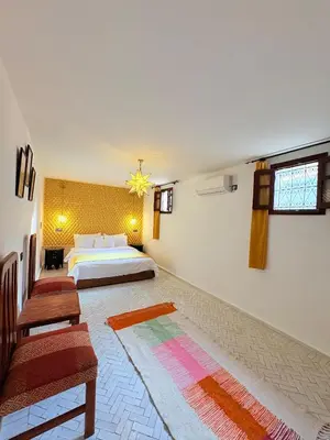 a large bedroom with a bed and a couch at Riad Dar Mazaj Fes in Fès