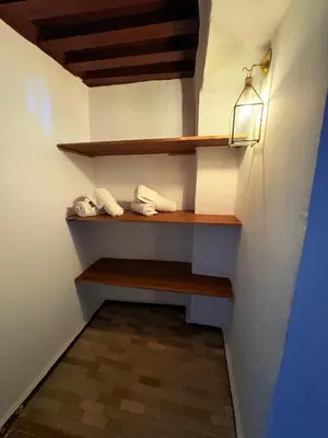 a hallway with wooden shelves and a light on the wall at Riad Dar Mazaj Fes in Fès