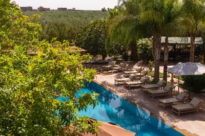 a swimming pool with lounge chairs and umbrellas at Hacienda de Julie in Sraïri