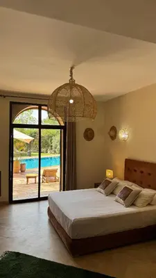 a bedroom with a large bed with a view of a pool at Hacienda de Julie in Sraïri