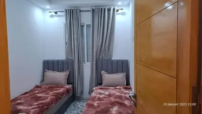 two beds sitting next to each other in a room at maison 83 in Oulad Akkou