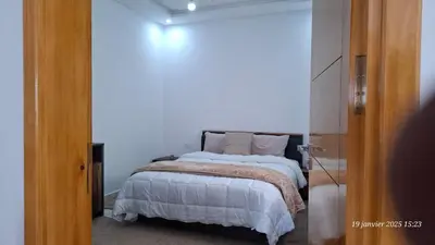 a bedroom with a bed with white sheets and pillows at maison 83 in Oulad Akkou