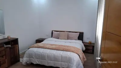 a bedroom with a large bed with white sheets and pillows at maison 83 in Oulad Akkou