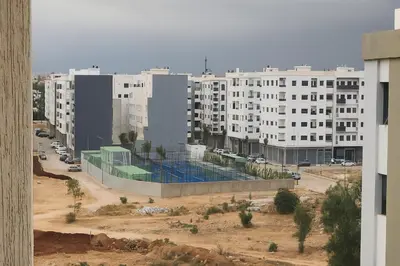 a building with a swimming pool in front of a city at Nakal in Fès