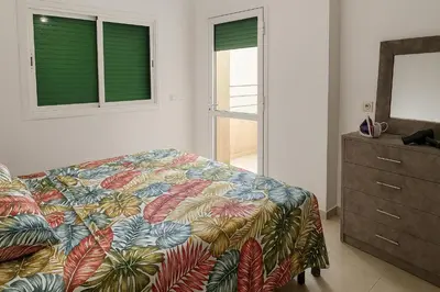 a bedroom with a bed and a dresser and windows at Nakal in Fès