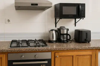 a kitchen counter with a stove and a microwave at Nakal in Fès