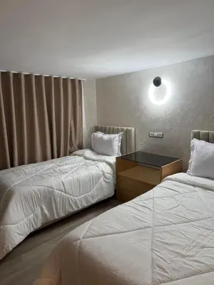 a hotel room with two beds and a desk at Illy house in Ifrane