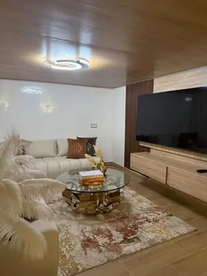 a living room with a couch and a flat screen tv at Illy house in Ifrane