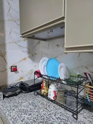a kitchen counter with plates and dishes on a shelf at Narjiss Hostel in Fès