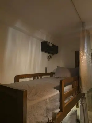 a bedroom with a bed with a television on the wall at Narjiss Hostel in Fès