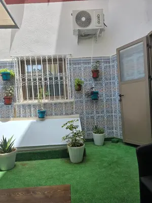 a room with a white tub and green grass at Narjiss Hostel in Fès