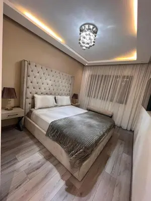 a bedroom with a large bed and a chandelier at Appartement T4 in Taza