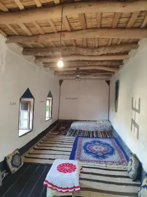 a bedroom with a bed with a rug on the floor at Tamrdulte in Tinerhir