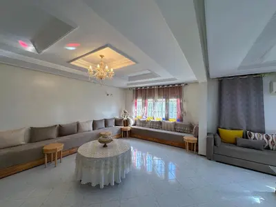 a large living room with couches and a table at Appartement Spacieux résidence privée surveiller in Fès