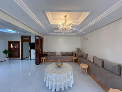 a living room with a couch and a table at Appartement Spacieux résidence privée surveiller in Fès