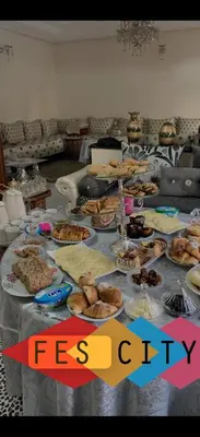 a table with many plates of food on it at Appartement Spacieux résidence privée surveiller in Fès