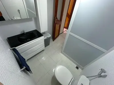 a bathroom with a white toilet and a sink at Appartement Spacieux résidence privée surveiller in Fès