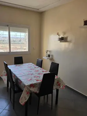 a dining room with a table and chairs and a window at andalus in Fès
