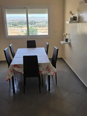 a dining room with a table with chairs and a window at andalus in Fès
