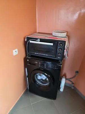 a washer and dryer in a corner of a room at andalus in Fès