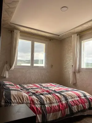 a bedroom with a bed and two windows at Absolute Calm & Panoramic Views in Oulad Akkou
