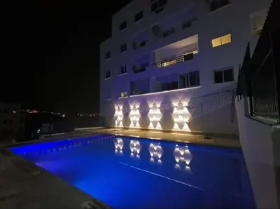 a swimming pool with lights in front of a building at Absolute Calm & Panoramic Views in Oulad Akkou